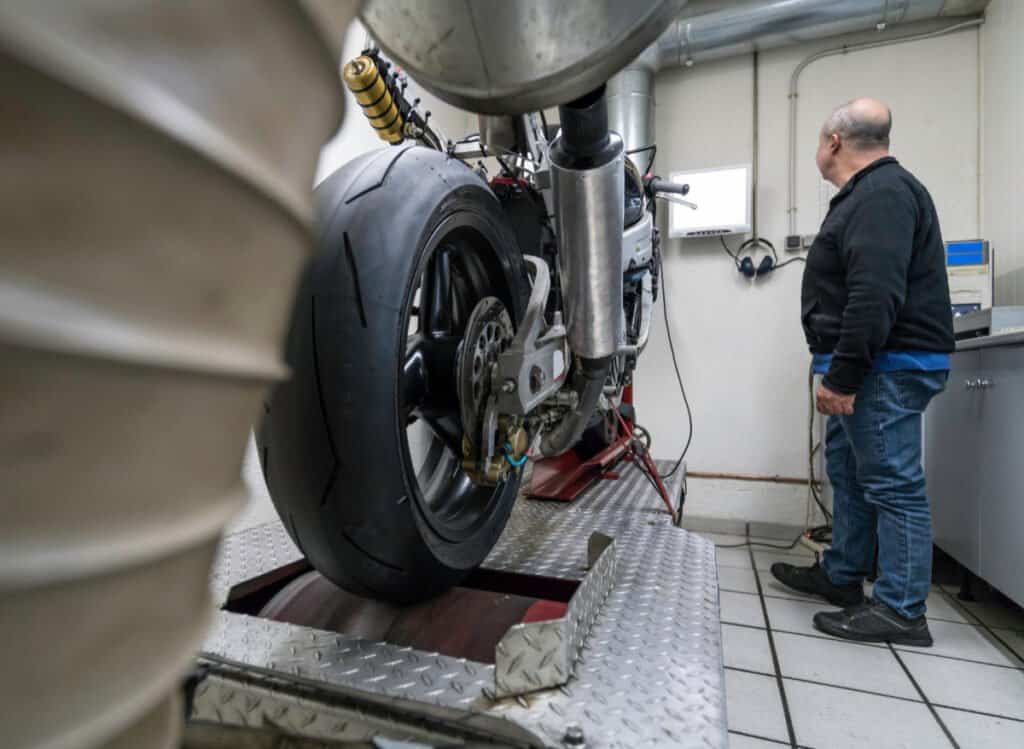 Engineer testing power of a motorcycle by dyno.